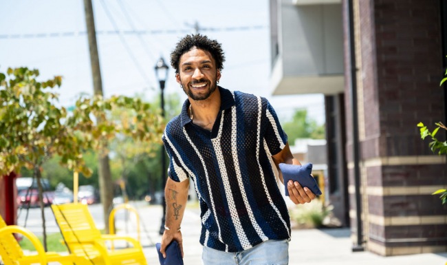 Smiling man playing cornhole Smiling man playing cornhole
